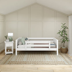 Modern kids' bedroom design with white daybed, nightstand, indoor plant, and geometric rug.