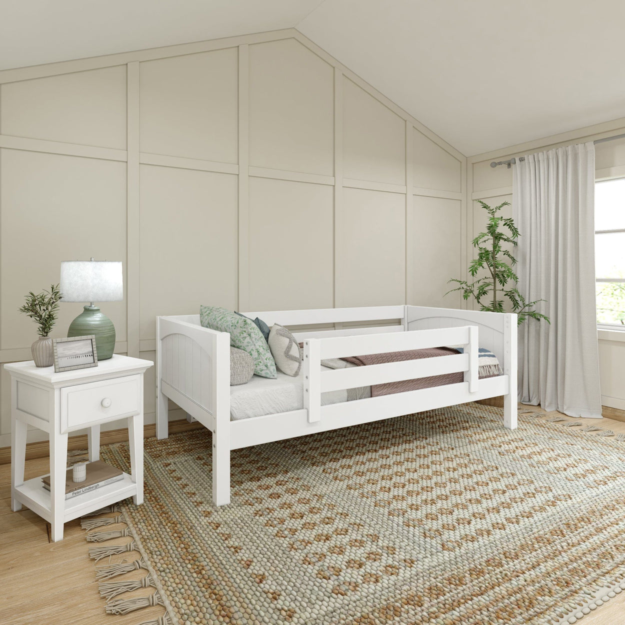 Cozy children's bedroom with white wooden bed, decorative pillows, bedside table, lamp, and patterned rug.