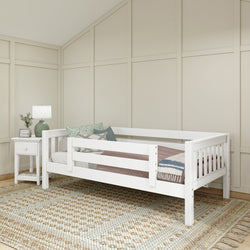White wooden daybed with guardrails, cozy pillows, and a side table in a modern bedroom setting.