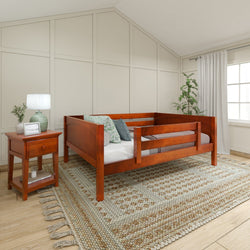 Rustic wooden toddler bed in cozy bedroom with nightstand and large rug.