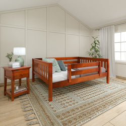 Cozy bedroom with wooden toddler bed, decorative pillows, bedside table, and woven rug.