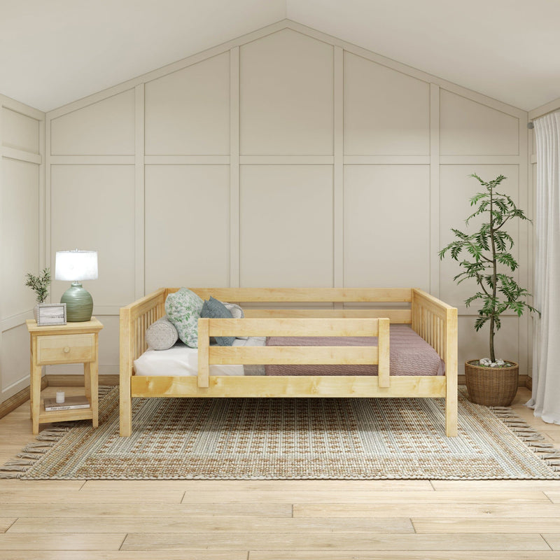 Neutral modern nursery with natural wood toddler bed, board-and-batten accent wall, green bedside lamp, textured woven rug and potted plant