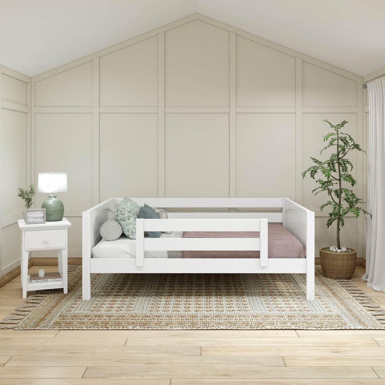 Stylish small bedroom interior with a white daybed, cozy pillows, and a green bedside lamp on a wooden nightstand.