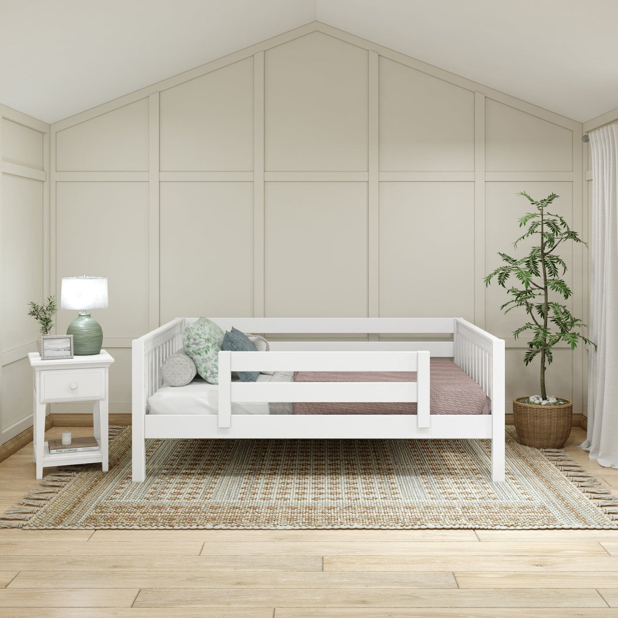 White daybed with side railings in a modern bedroom featuring a woven rug, nightstand with lamp, and potted plant, perfect for minimalist interior design.