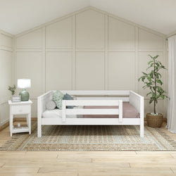 White daybed with side railings in a modern bedroom featuring a woven rug, nightstand with lamp, and potted plant, perfect for minimalist interior design.