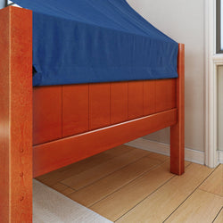 Wooden bed frame with blue duvet cover over beige floor in bright bedroom.