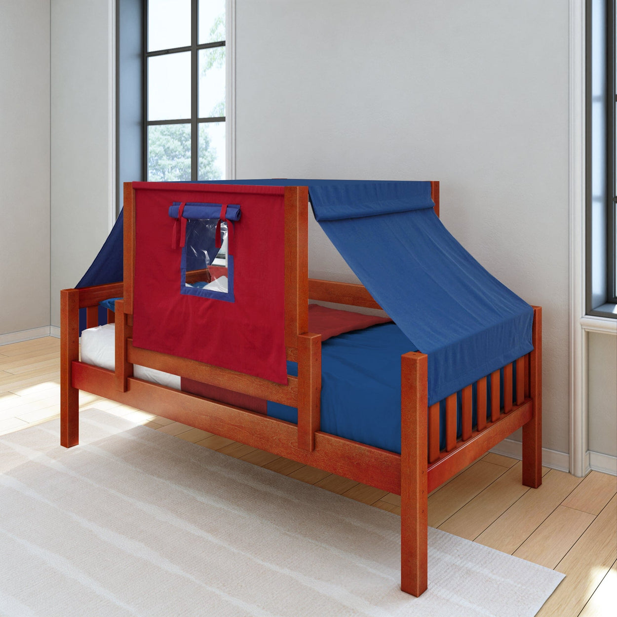 Wooden children's bed with red and blue play tent canopy in a sunlit bedroom.