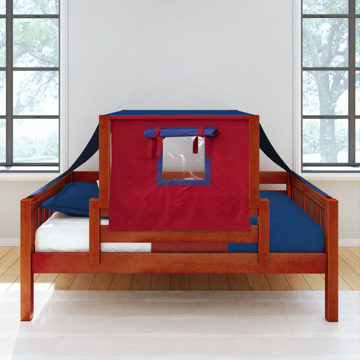 Wooden bed with a red and blue play tent canopy, featuring a window, in a bright room with large windows.