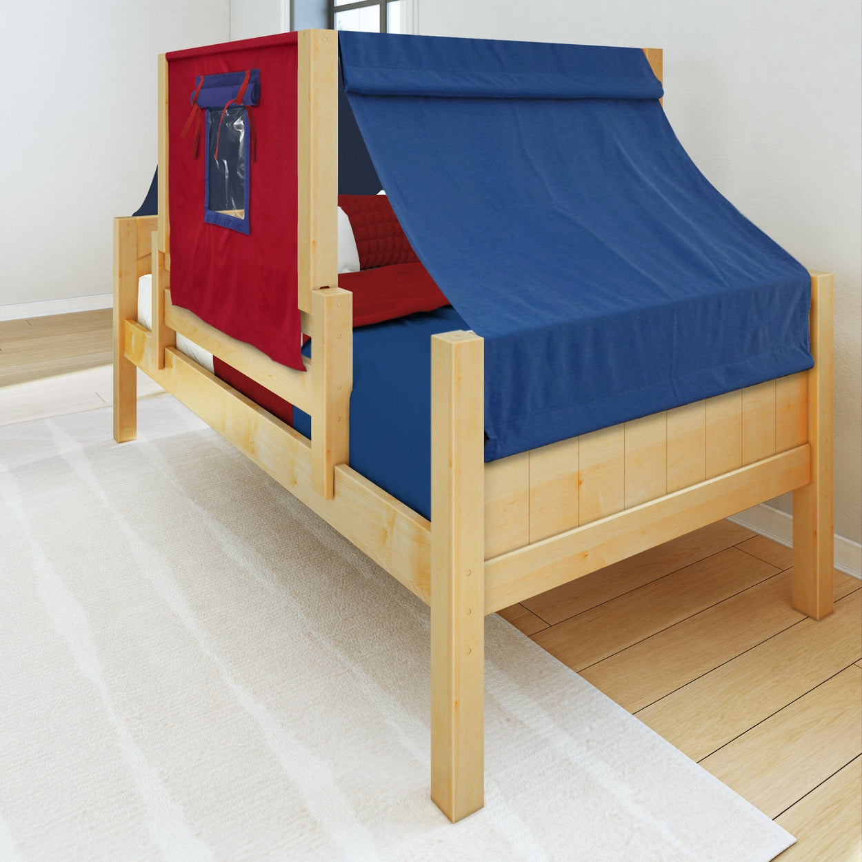 Wooden kids bed with red and blue canopy, creating a cozy, tent-like feel in a bright bedroom.