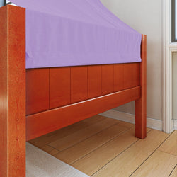 Wooden bed frame with purple bedsheet in sunlit bedroom.
