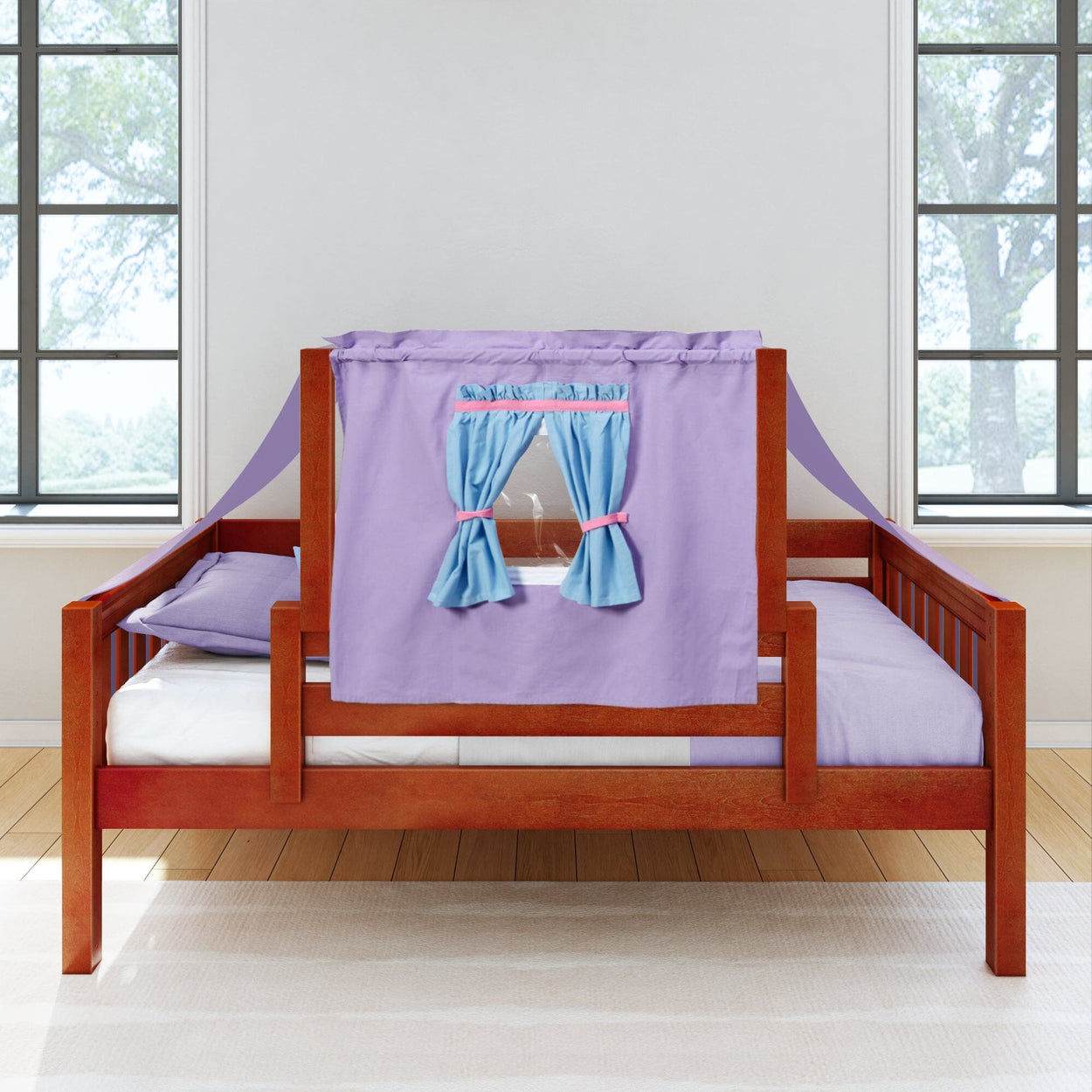 Wooden children's bed with a purple play tent and blue curtains in a bright bedroom.
