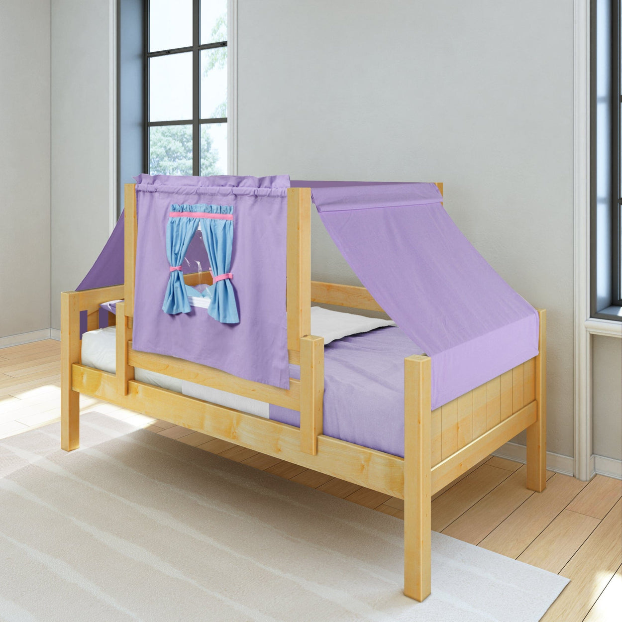 Wooden children's bed with purple tent-style canopy and blue window curtains in a bright room.