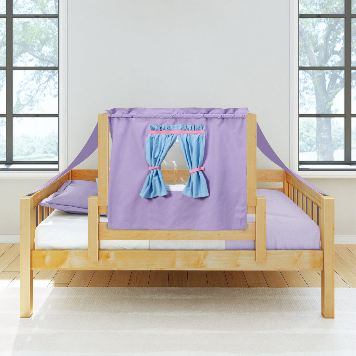 Children's wooden bed with purple canopy and blue curtains in bright bedroom.