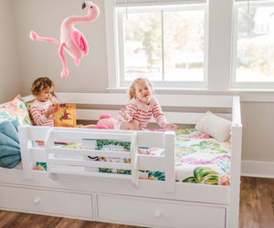 Twins playing in their toddler bed