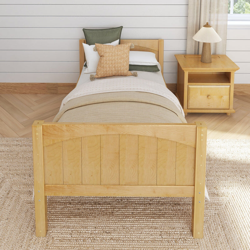 Cozy farmhouse bedroom with single natural wood bed, neutral bedding and textured woven pillows, wooden nightstand with lamp, white shiplap wall and herringbone wood floor