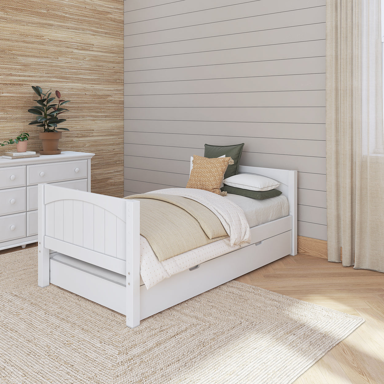 Cozy bedroom with white wooden bed frame and beige bedding set, featuring a potted plant and dresser against shiplap wall, ideal for modern home decor inspiration.