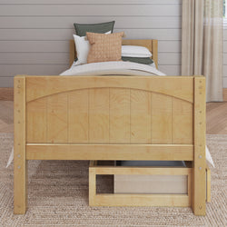 Wooden twin bed with storage drawer and cozy bedding in a modern bedroom.