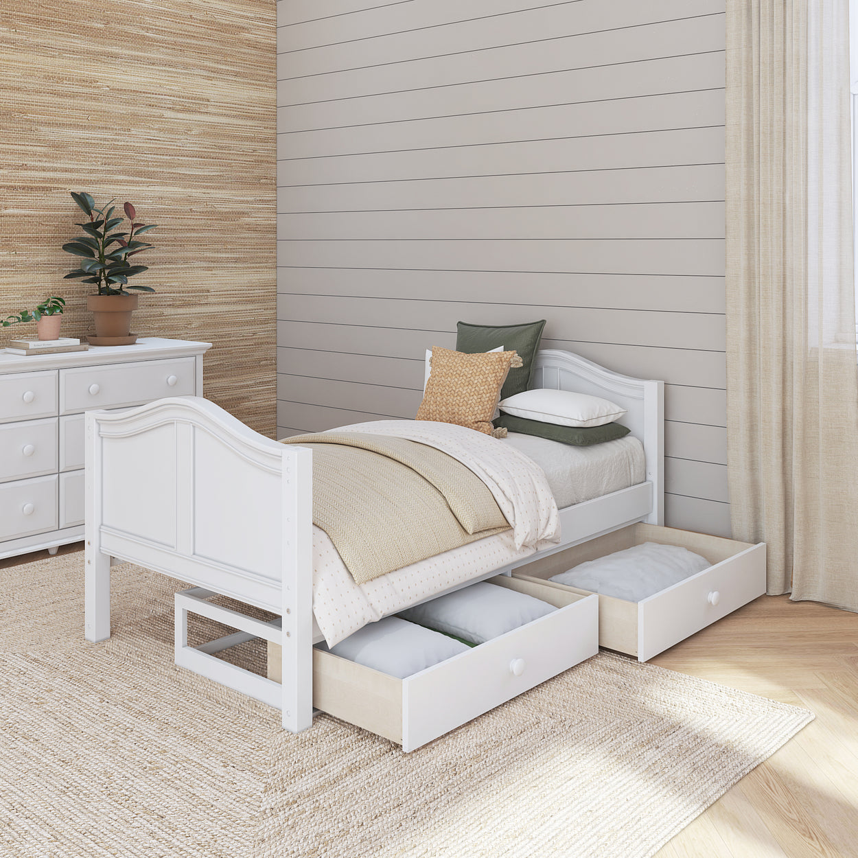 Modern wooden bedroom with a white single bed featuring under-bed storage drawers on a cozy carpet, accented by neutral decor and a potted plant.