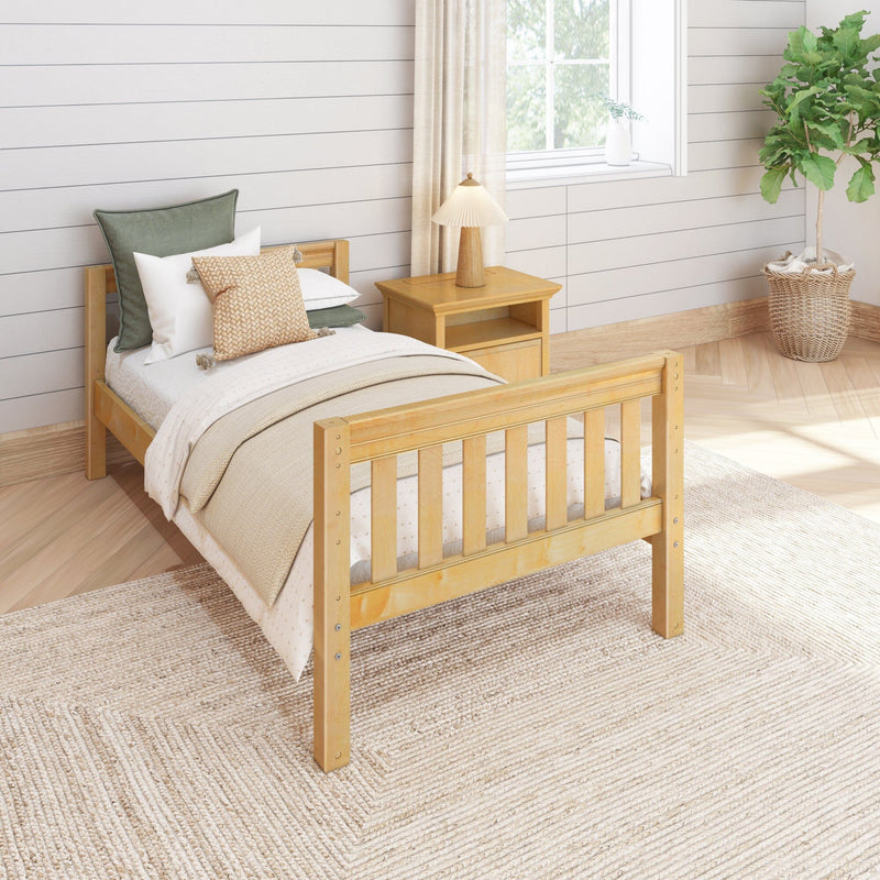 Cozy farmhouse bedroom with light wood bed, neutral bedding, woven rug, nightstand lamp, shiplap wall and fiddle-leaf fig.