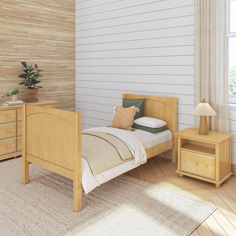 Cozy bedroom with light wood bed, neutral decor, white shiplap wall, woven rug, bedside lamp and potted plants
