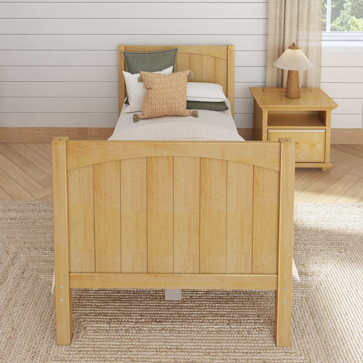 Single wooden bed with cozy pillows in a modern bedroom setting.