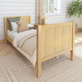 Cozy sunlit farmhouse bedroom with light wooden bed frame, neutral bedding and knit pillows, woven jute rug, shiplap wall, bedside lamp and potted fiddle leaf fig