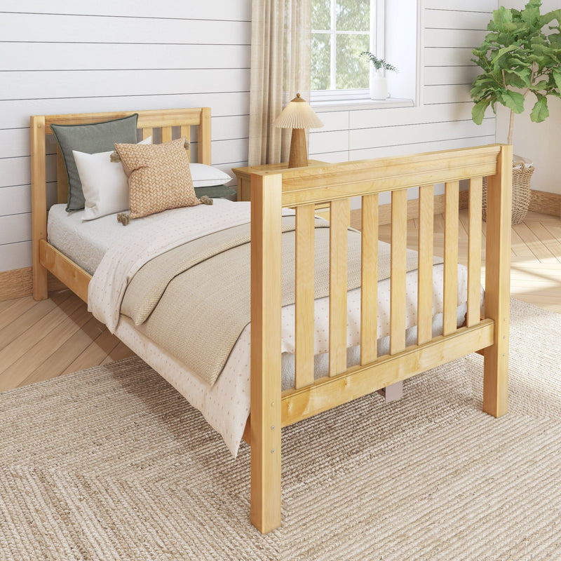 Cozy farmhouse bedroom with natural wooden bed frame, neutral bedding and knit pillows, woven jute rug, shiplap wall and bedside lamp
