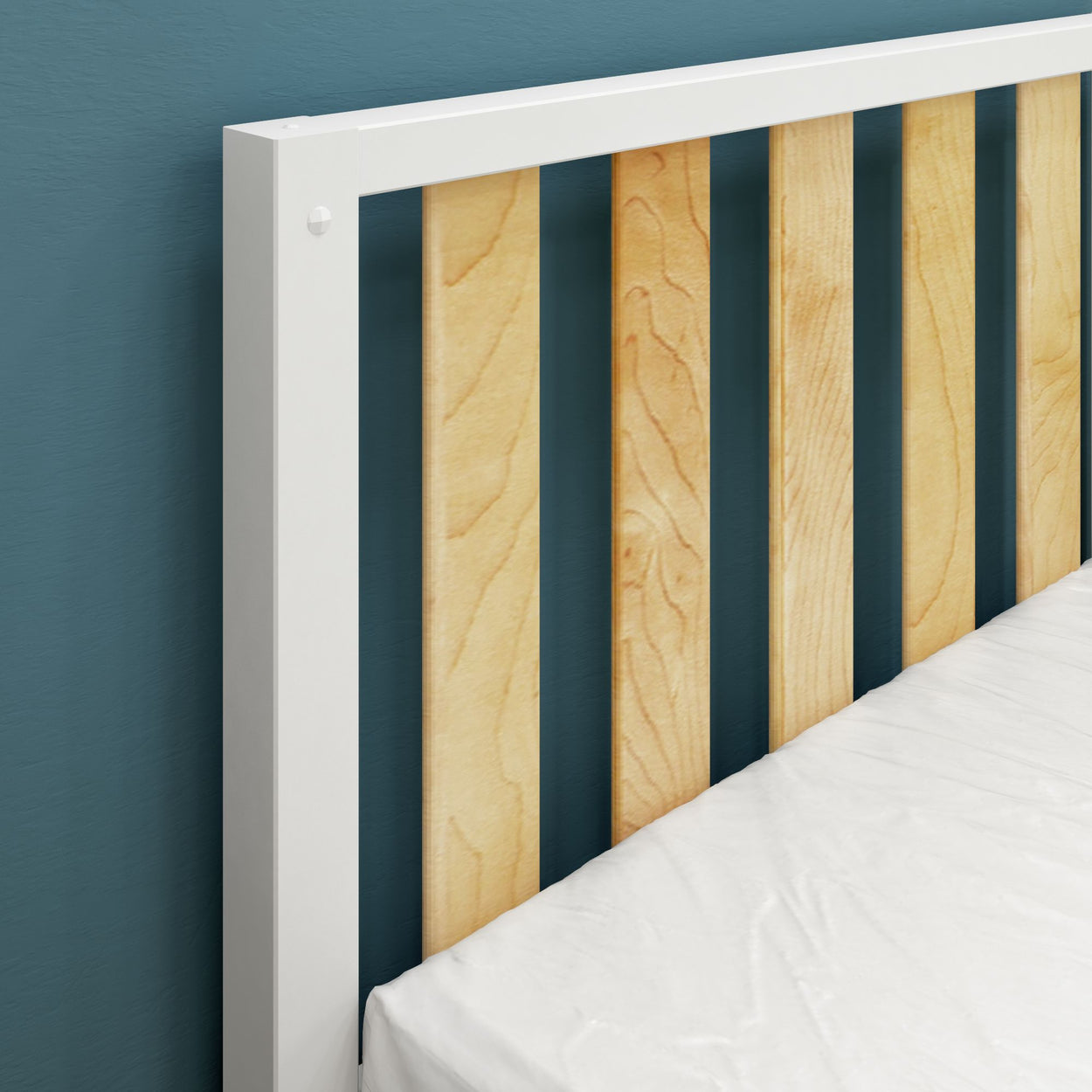 Wooden bed frame with white mattress against blue wall, modern minimalist bedroom design.
