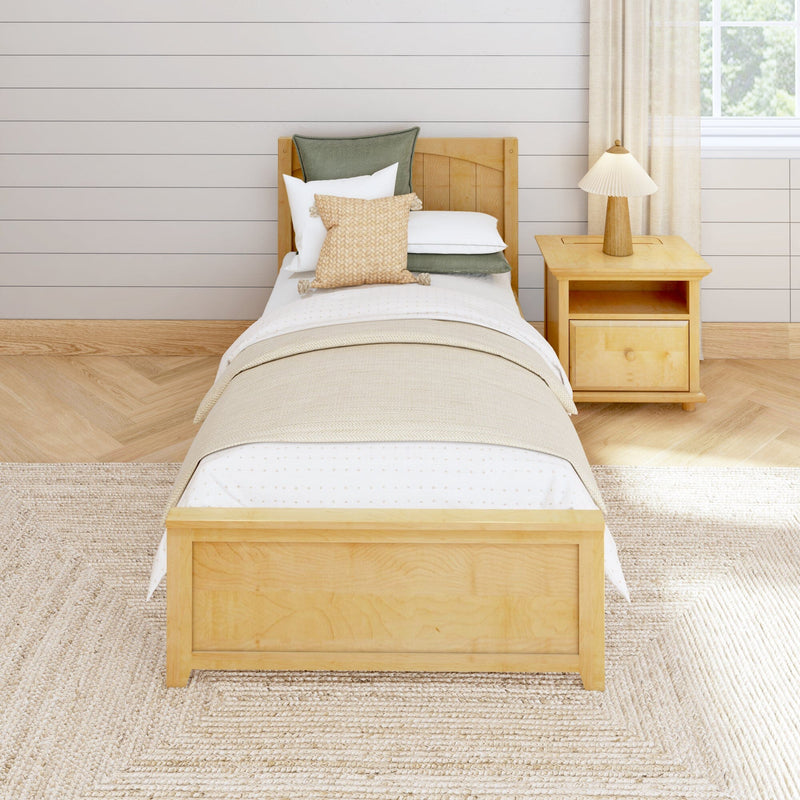 Cozy minimalist farmhouse twin bedroom with natural wood bed and nightstand, beige bedding, woven accent pillows, pleated lamp, shiplap wall, and light hardwood floor