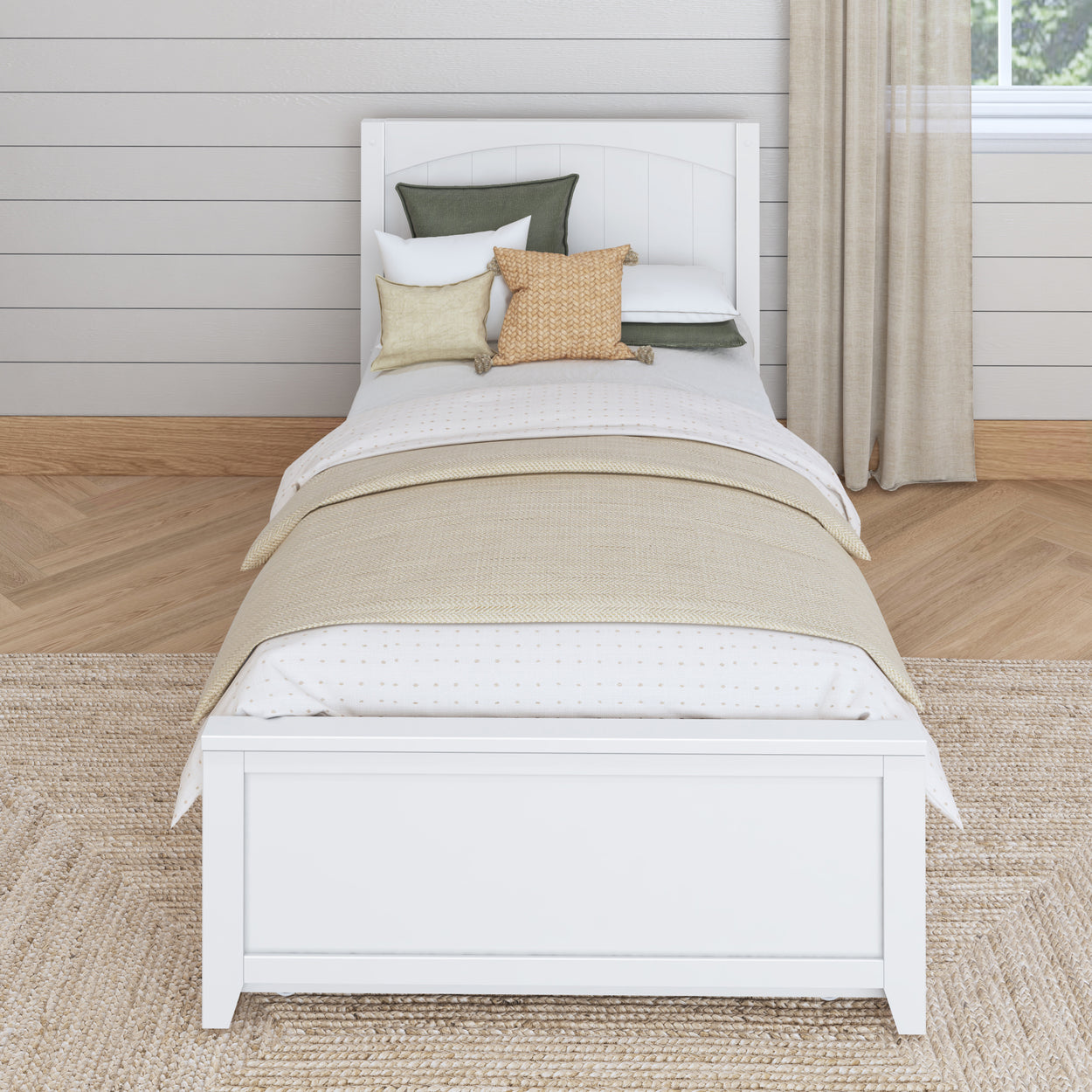 Single bed with white frame and layered pillows in a cozy bedroom setting.