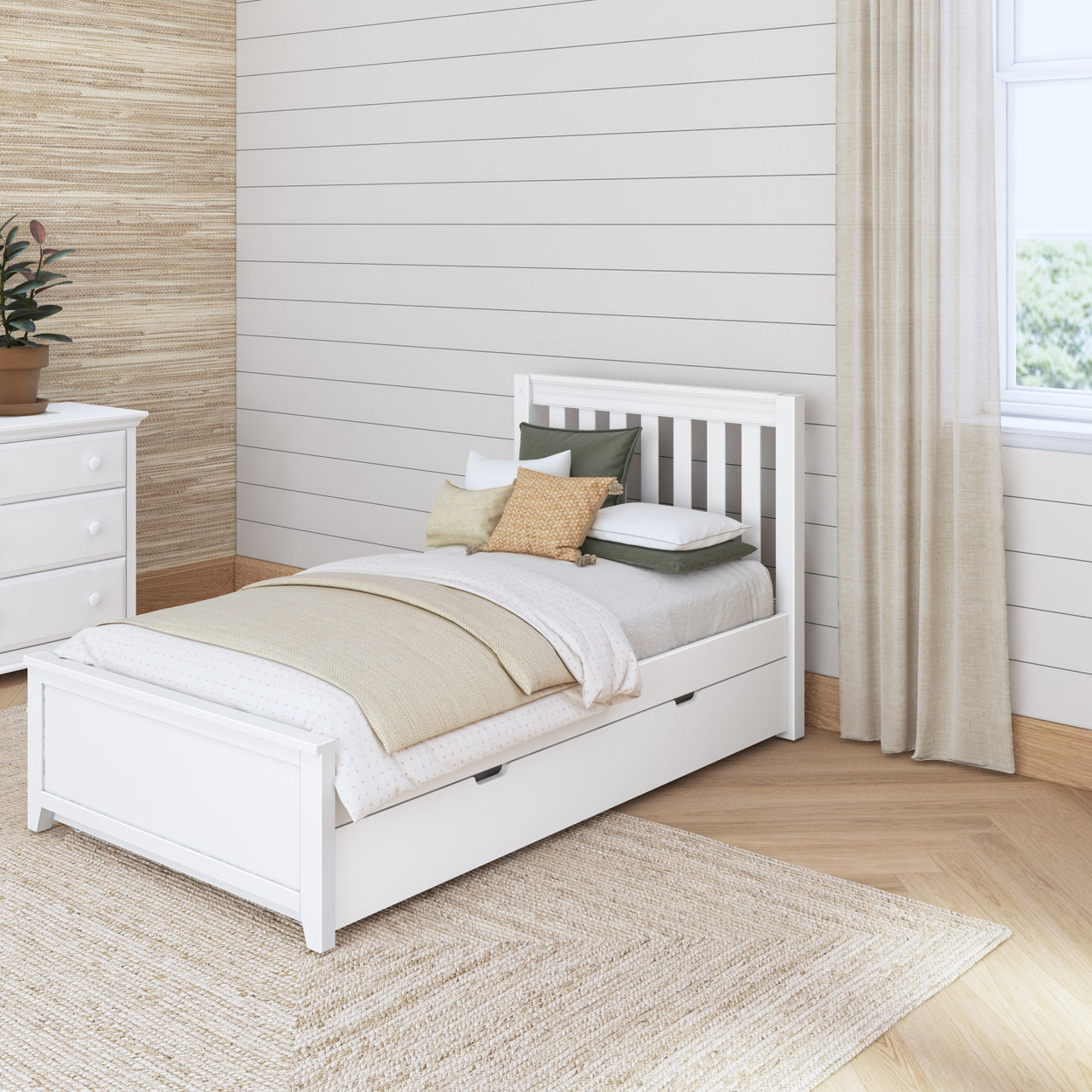 Cozy bedroom with a white bed and earthy accents featuring a stylish storage drawer, neutral-toned cushions, and a potted plant for modern interior design.