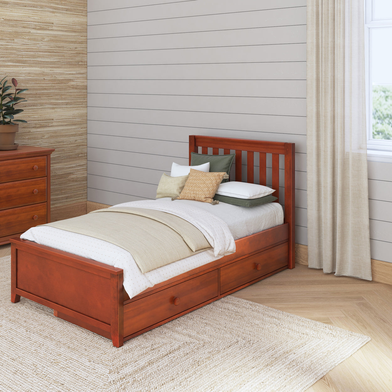 Single wooden bed with storage drawers in a cozy bedroom setting with natural light and a plant.