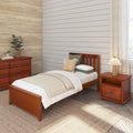 Cozy bedroom with wooden bed and nightstand, neutral bedding, shiplap accent wall, wooden dresser, potted plants and textured rug