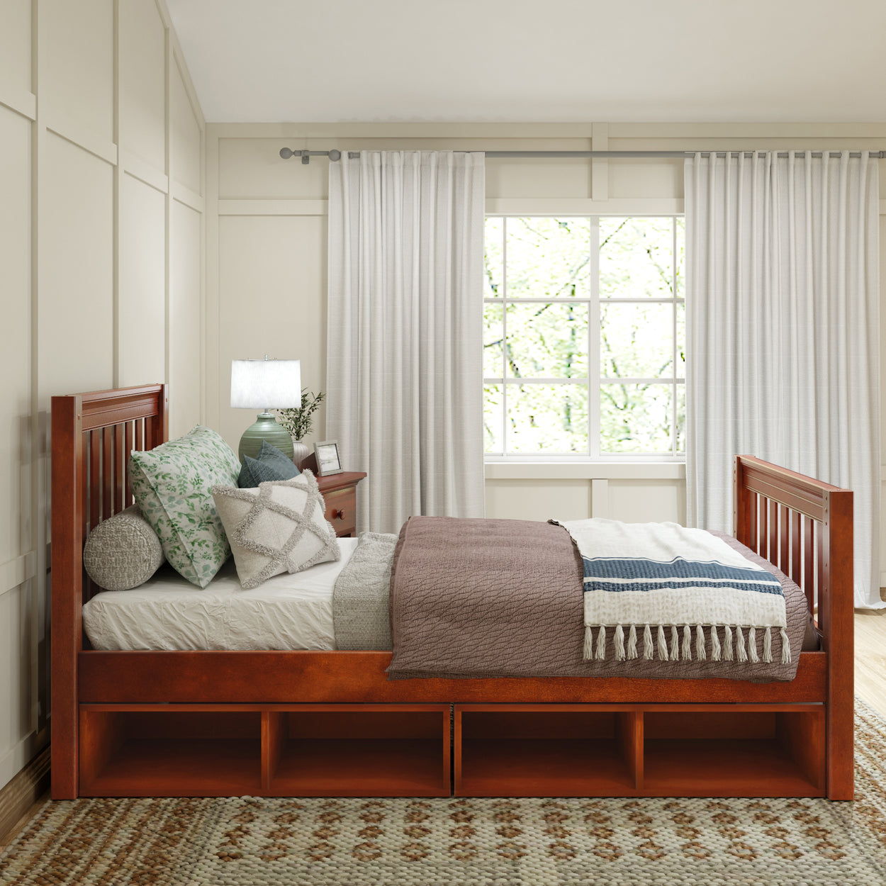 Cozy bedroom with a wooden bed frame featuring storage, adorned with decorative pillows and a soft blanket, complemented by natural light from a large window.