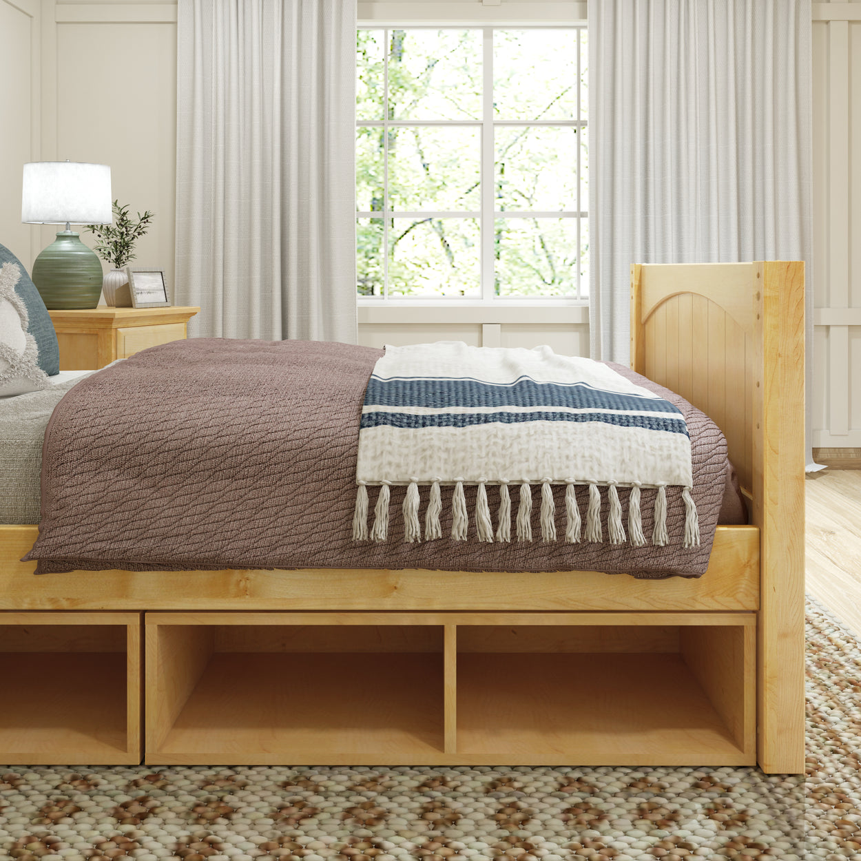 Cozy bedroom interior with modern wooden bed frame, decorative throw blanket, and elegant bedside lamp in natural light setting.