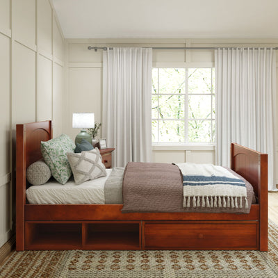 Cozy bedroom with wooden bed frame, decorative pillows, and natural light filtering through white curtains.