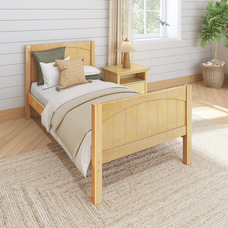 Neutral bedroom with light wood twin bed, layered beige bedding and woven throw pillow, jute rug, wood nightstand with lamp and potted plant