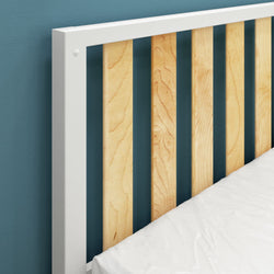 Modern wooden slatted headboard design with white accents against teal wall background.
