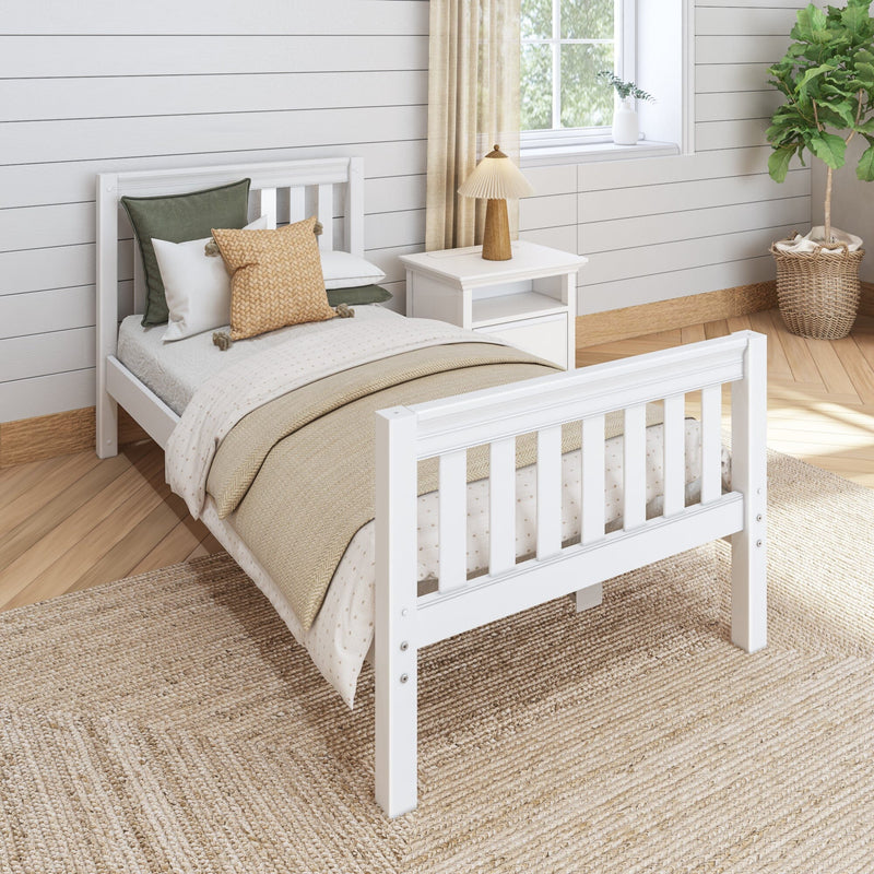 Cozy neutral modern farmhouse bedroom with white wooden bed, layered beige and green bedding, woven accent pillows, white nightstand with wooden lamp, shiplap walls, jute rug and potted fiddle leaf fig by window