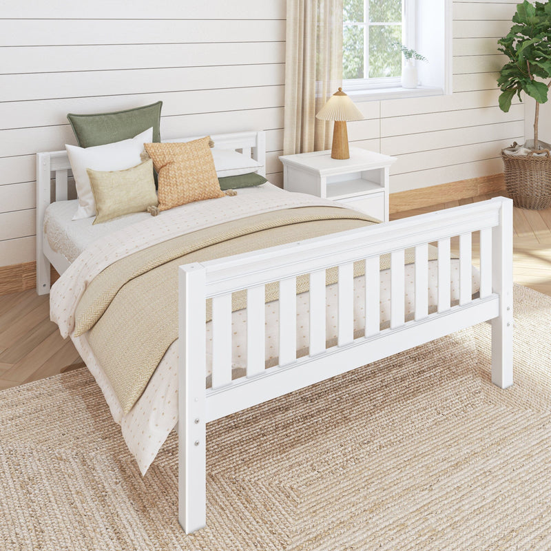 Cozy farmhouse bedroom with white wooden bed, neutral textured bedding and pillows, bedside table with wooden lamp, shiplap walls and wicker rug