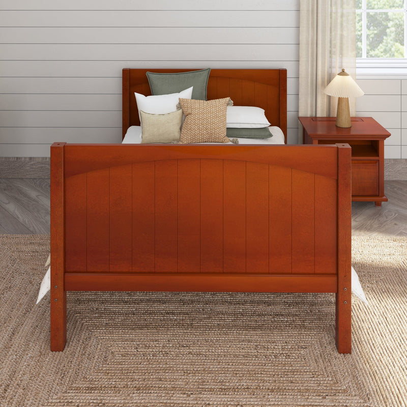 Orange wooden bed with neutral pillows, bedside table and lamp, white shiplap wall and woven jute rug in farmhouse bedroom