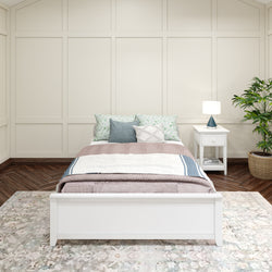 Cozy bedroom interior with white bed, decorative pillows, nightstand, lamp, and potted plant.