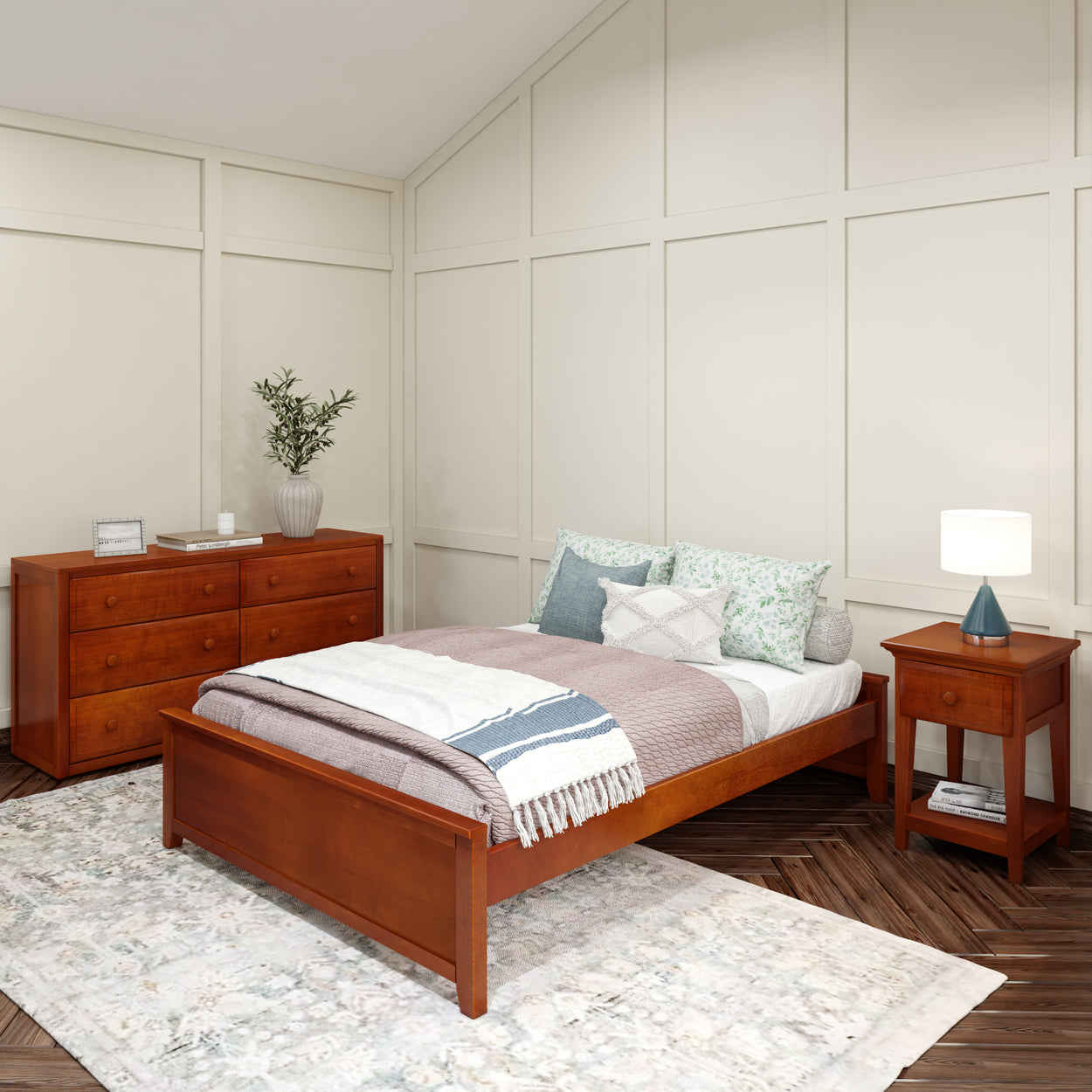 Cozy bedroom with wooden bed frame, dresser, and nightstand, featuring soft pastel bedding and decorative cushions for a relaxing atmosphere.