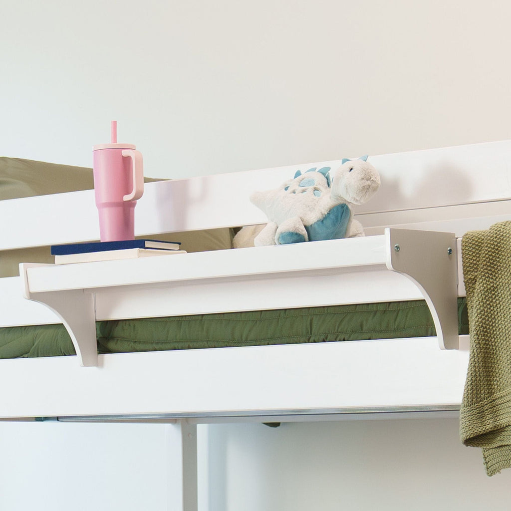 White bunk bed shelf in children's bedroom with green bedding, blue dinosaur plush toy, pink insulated tumbler and stacked books.