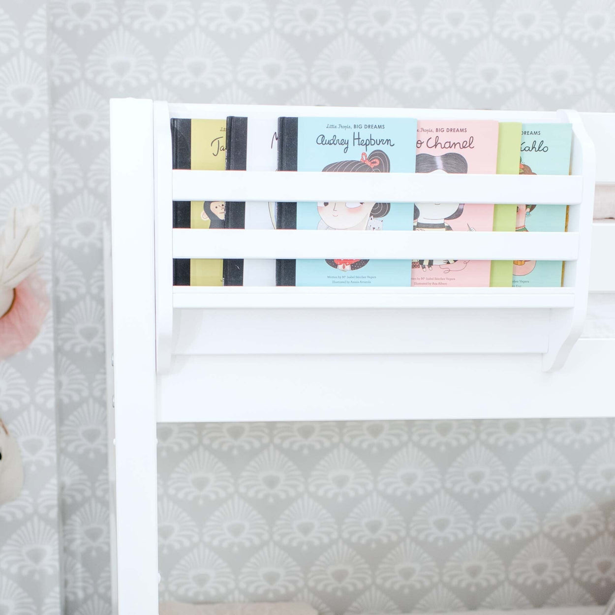 White toddler bed bookshelf displaying colorful children's board books facing forward — nursery decor, kids room reading nook