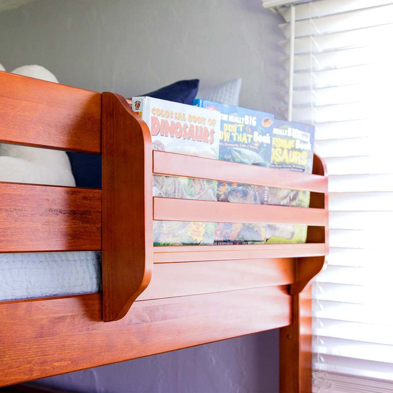 Cherry wood upper bunk bed with built-in front bookshelf holding children's dinosaur books in a kids' bedroom next to white window blinds