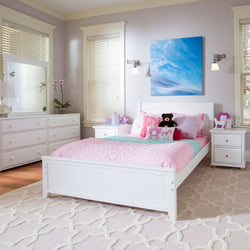 Bright modern children's bedroom with white furniture, pink bedding, and wall art, featuring a plush teddy bear and decorative accents.