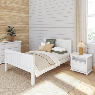 Cozy modern bedroom with a white wooden bed, natural woven rug, and soft neutral accents for a serene atmosphere.