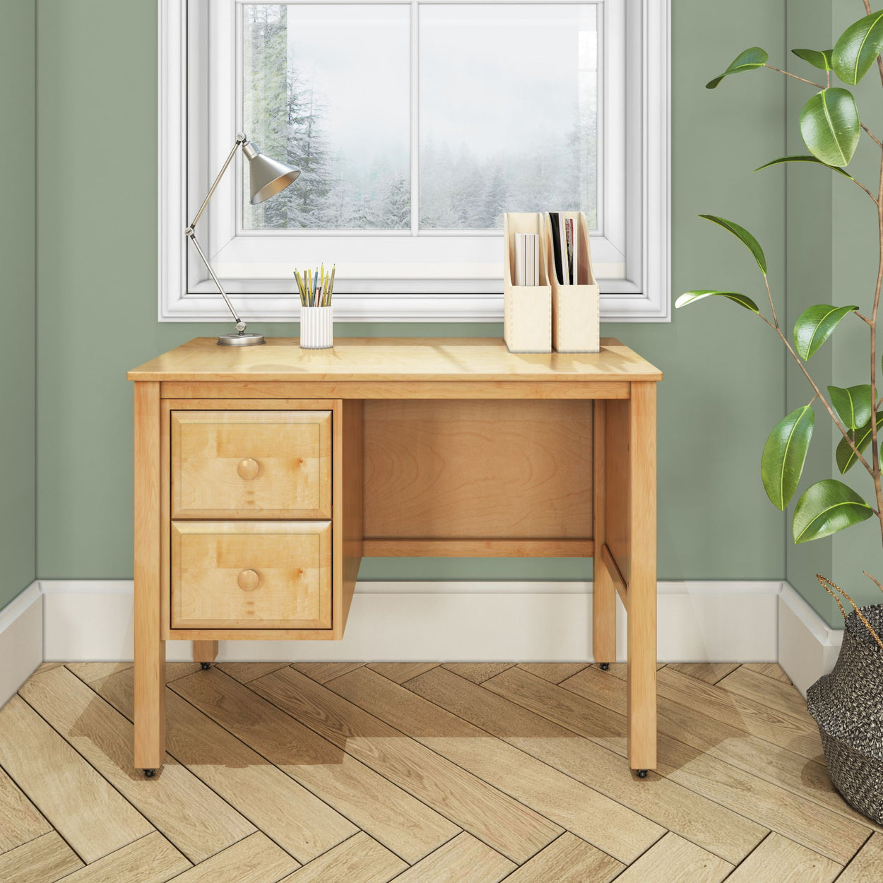 Stylish wooden desk with drawers and decor, placed near a window in a well-lit room with green walls and wooden flooring.