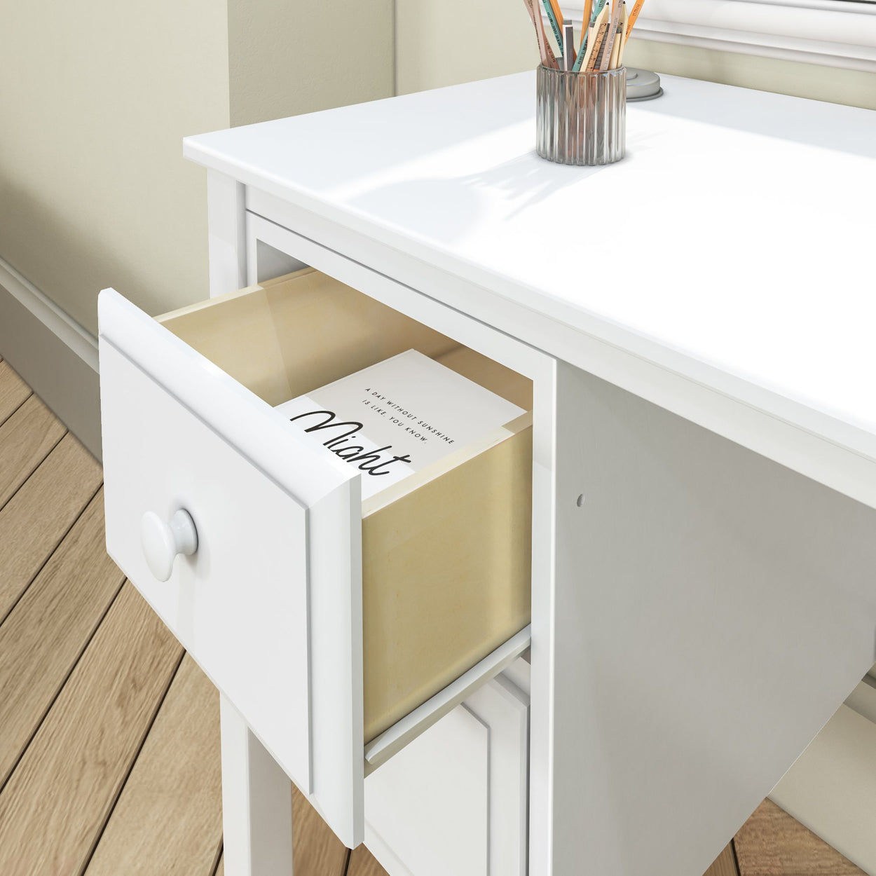 Open white desk drawer with stationery and a note, perfect for home office organization.